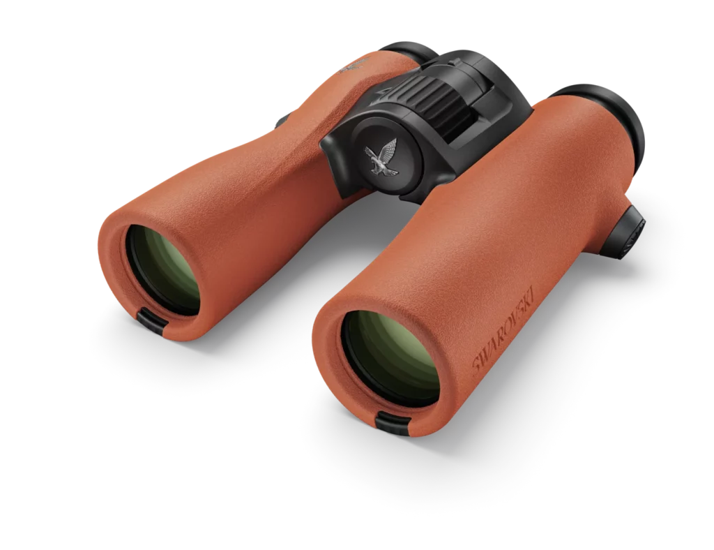 A pair of orange binoculars on a black background in Swarovski Optik NL Pure 10x32 Binocular Review.